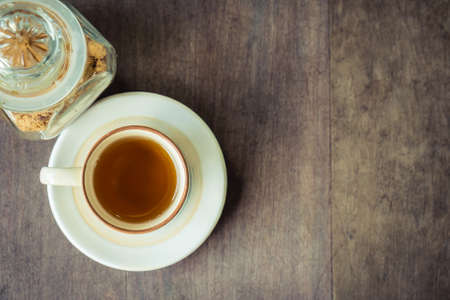 Small cup of tea with brown sugar on wood table backgroundの写真素材