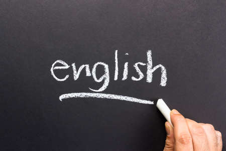 Hand writing English topic on chalkboard