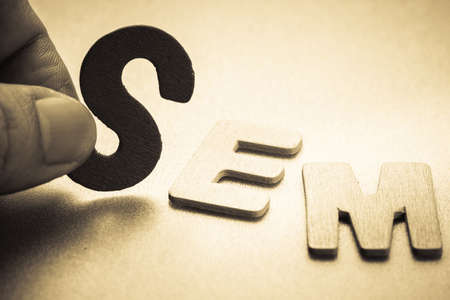 Closeup finger picking a small English letter to put in the SEM (Search Engine Marketing)  abbreviationの写真素材