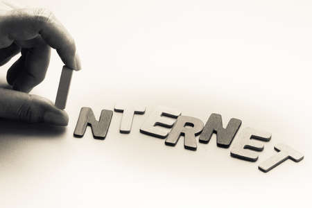 Closeup finger pick an English letter of Internet wordの写真素材