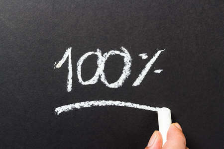Hand writing numbers of one hundred percent on chalkboardの写真素材