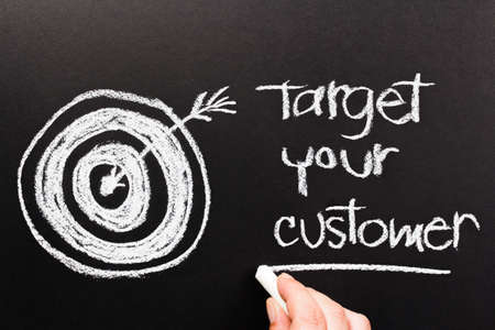 Target Your Customer with sketching dartboard on chalkboardの写真素材