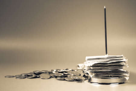 Pile of receipts in paper nail with coinsの写真素材