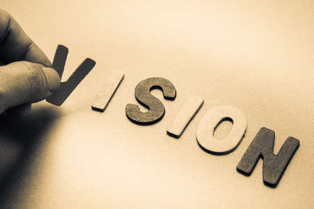 Finger pick a wood letters of Vision word
