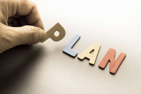 Finger pick a wood letters of Plan word