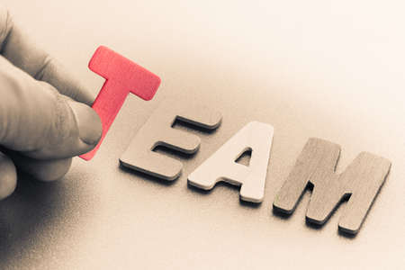 Finger pick a wood letters of Team word