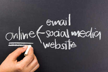 Hand writing a business online media on chalkboardの写真素材