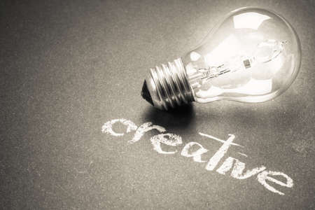Handwriting of Creative word with glowing light bulbの写真素材