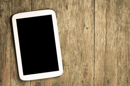 White tablet isolated black screen on wood backgroundの写真素材