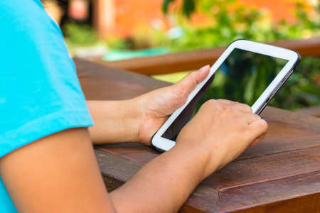 Closeup woman  using computer tablet outdoor