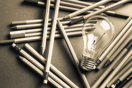 Creative writing, light bulb and many pencils on the tableの写真素材
