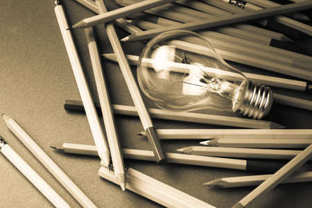 Creative writing, light bulb and many pencils on the tableの写真素材