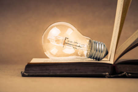 Opened old book with light bulbの写真素材