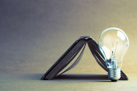 Glowing light bulb with old book turn upside downの写真素材