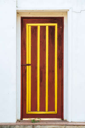 Wood door in white concrete wall, traditional Thai styleの写真素材