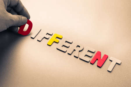 Hand arrange wood letters as Different wordの写真素材