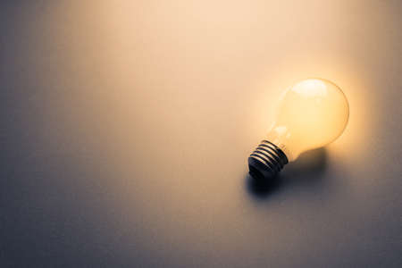 One light bulb glowing in darkness