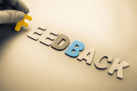 Hand arrange wood letters as Feedback word Hand arrange wood letters as Feedback word