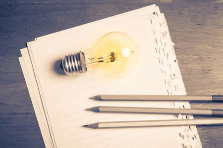 Pencils and light bulb on papers, creative writing concept