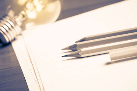 Pencils on papers with light bulb, creative writing conceptの写真素材