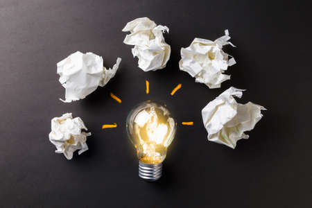 Glowing light bulb with crumpled paper spark