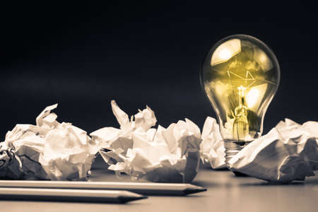 Light bulb among the crumpled paper as idea for writing concept