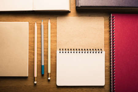 Many notebooks and pencils on wood tableの写真素材
