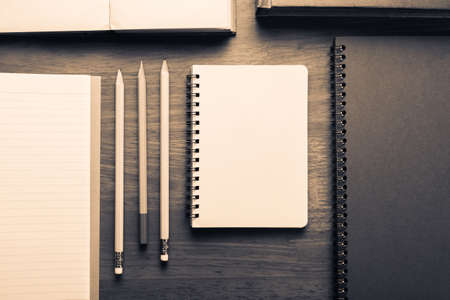 Many notebooks and pencils on wood tableの写真素材