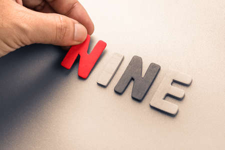 Hand arrange wood letters as Nine wordの写真素材