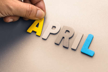 Hand arrange wood letters as April wordの写真素材