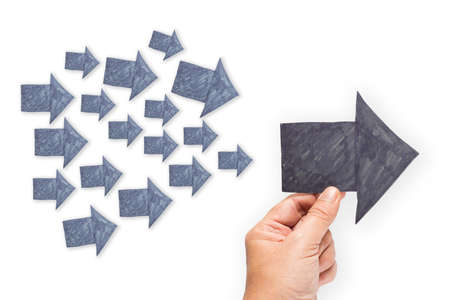 Hand hold a paper arrow as Trend Leader with many small arrows as followersの写真素材