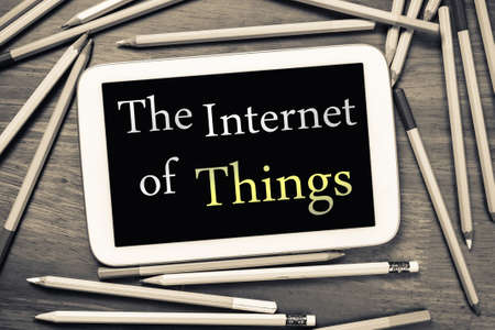 The Internet Of Things topic on mobile tablet with many pencils on wood tableの写真素材
