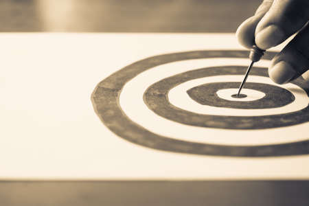 Hand take a dart into the center of drawing target, goal setting conceptの写真素材