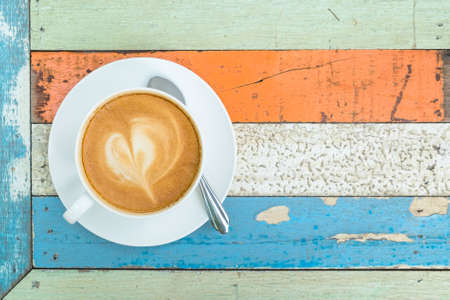 Cup of cappuccino on colorful wood tableの写真素材