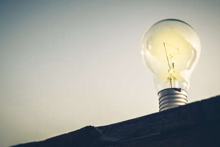 Light bulb glowing on silhouette plank, bottom view and vintage color styleの写真素材