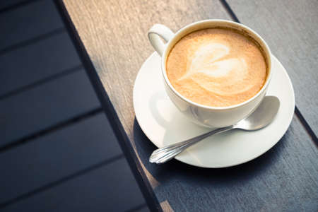 Cup of cappuccino outdoor on wood bench, retro color styleの写真素材