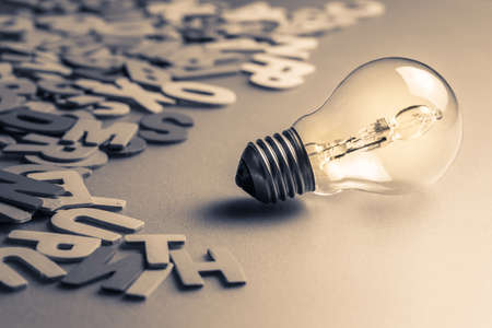 Light bulb and scattered wood lettersの写真素材