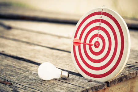 Dart hit the center of dartboard with light bulbの写真素材