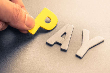 Hand arrange wood letters as Pay wordの写真素材