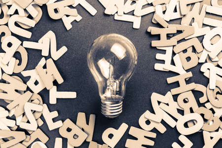 Light bulb in the middle of scattered wood letters