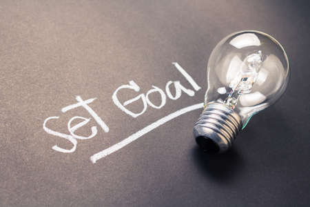 Handwriting of Set Goal text with glowing light bulbの写真素材