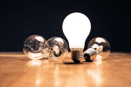 Comparative white light bulb standing on the tableの写真素材