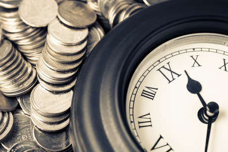 Closeup old clock with many coinsの写真素材