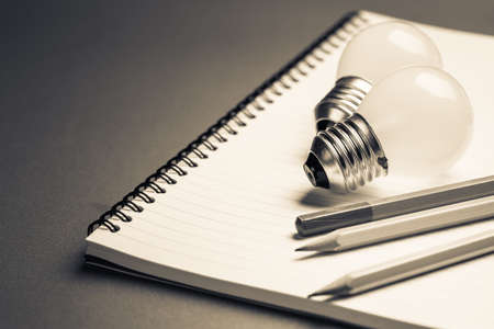 Light bulbs and pencils on notebook for creative writing concept