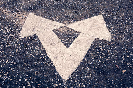 Vintage photo of separate arrow sign on old roadの写真素材