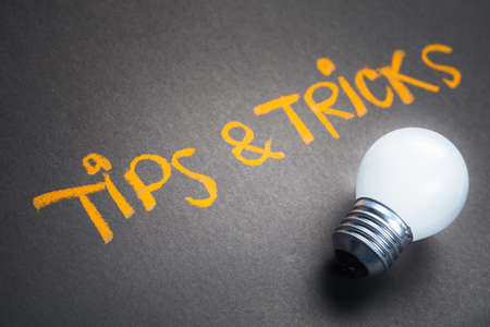 Tips and Tricks, handwriting on chalkboard with glowing light bulb