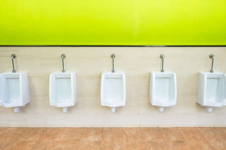 Urinals on green and tiled wallの写真素材