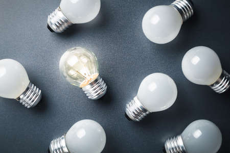 Different light bulb glowing among the group of white light bulbs