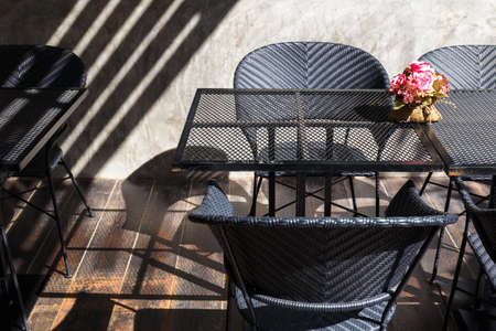 Dining Corner, meshed dining table and weaved plastic chairs, abstract composition with light and shadowの写真素材