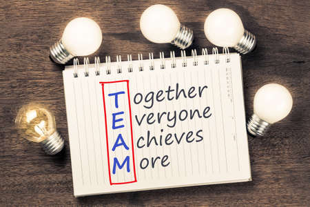Team acronym on notebook with many glowing light bulbsの写真素材
